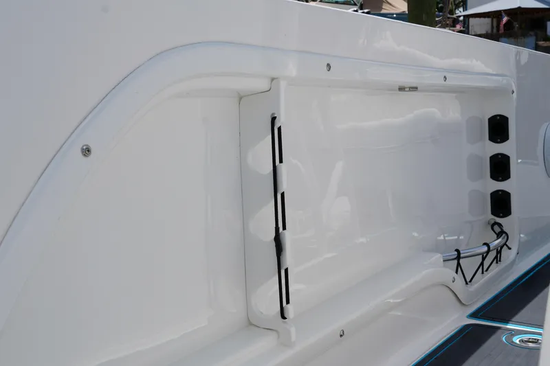 Slide: The Image of 2024 Twin Vee 240 GFX CC boat interior detail, showcasing sleek white paneling and storage features. - 37