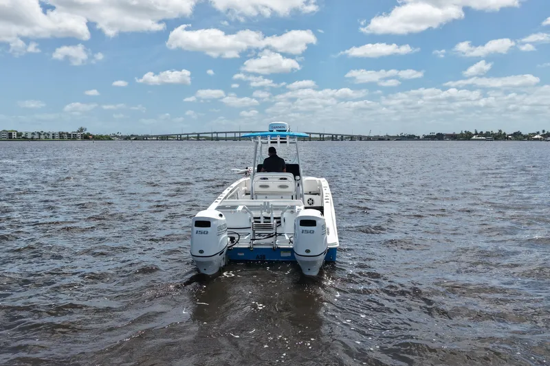 Slide: The Image of 2024 Twin Vee 240 GFX CC boat on open water under a cloudy sky. - 4