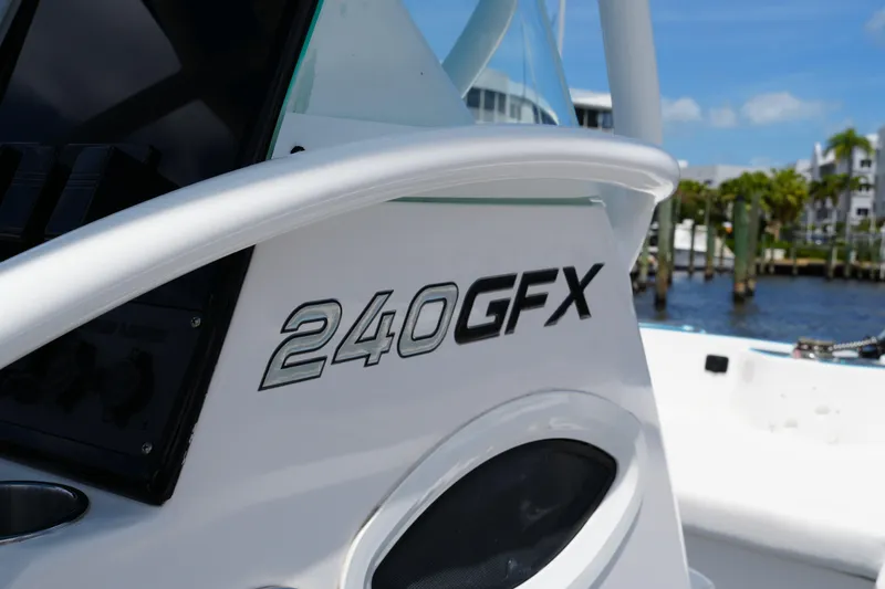 Slide: The Image of 2024 Twin Vee 240 GFX CC boat detail with logo, dockside view. - 45
