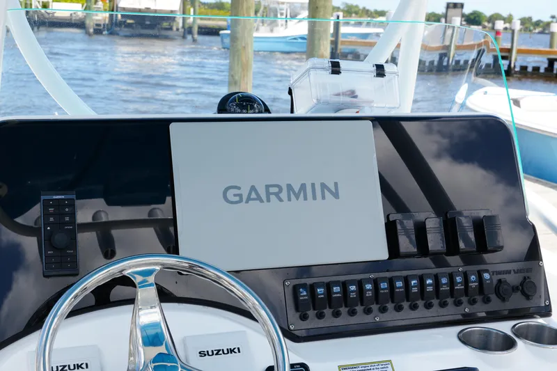 Slide: The Image of 2024 Twin Vee 240 GFX CC boat dashboard with Garmin navigation system and Suzuki controls. - 47