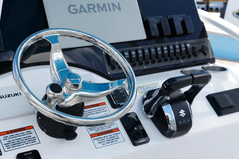 Slide: The Image of Steering console of 2024 Twin Vee 240 GFX CC with Garmin display and Suzuki controls. - 48