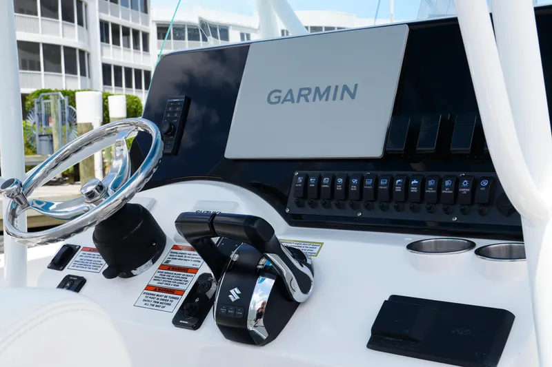 Slide: The Image of 2024 Twin Vee 240 GFX CC boat dashboard with Garmin navigation system and Suzuki controls. - 49