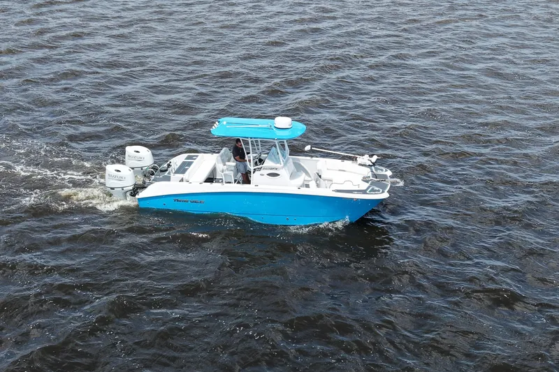 Slide: The Image of 2024 Twin Vee 240 GFX CC boat cruising on open water, featuring dual Suzuki engines. - 5