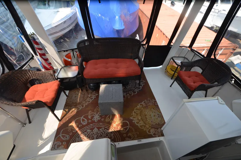Slide: The Image of 1991 Carver 33 Aft Cabin interior with wicker seating and patterned rug. - 10