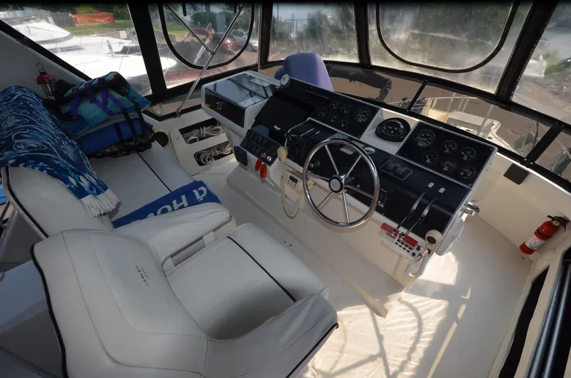 Slide: The Image of 1991 Carver 33 Aft Cabin helm with steering wheel, gauges, and seating. - 12
