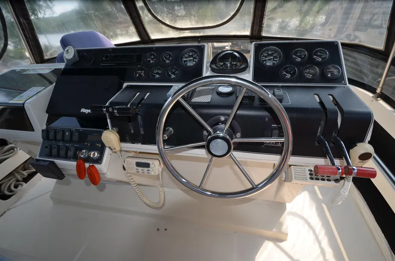 Slide: The Image of 1991 Carver 33 Aft Cabin helm with steering wheel and control panel. - 13