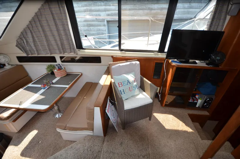 Slide: The Image of Interior of 1991 Carver 33 Aft Cabin with seating, table, and TV. - 21