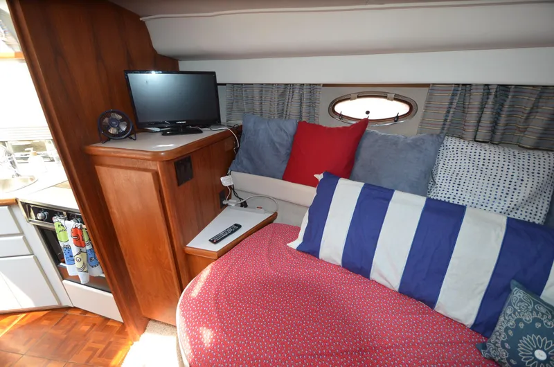 Slide: The Image of Cozy interior of 1991 Carver 33 Aft Cabin with TV and colorful cushions. - 27