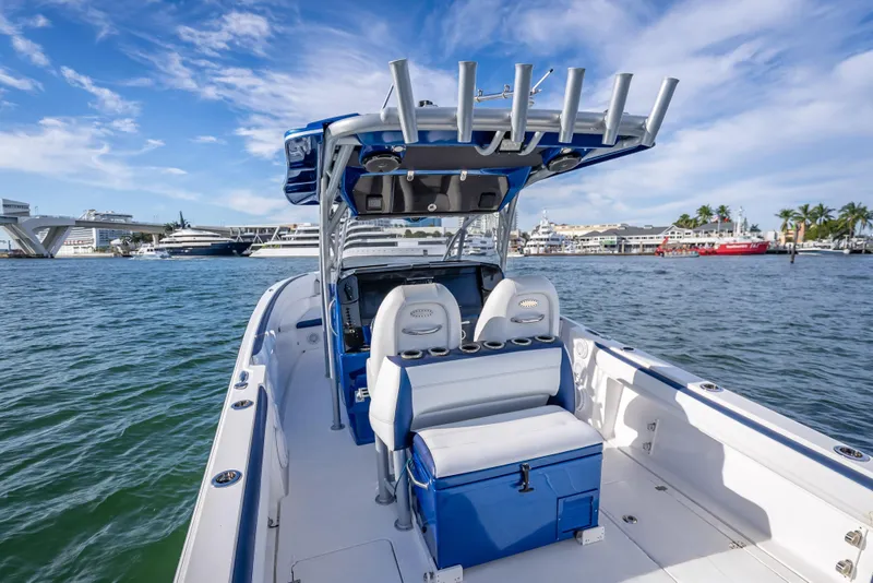 Slide: The Image of 2015 Nor-Tech 340 Sport Center Console boat on water, clear sky, marina background. - 17