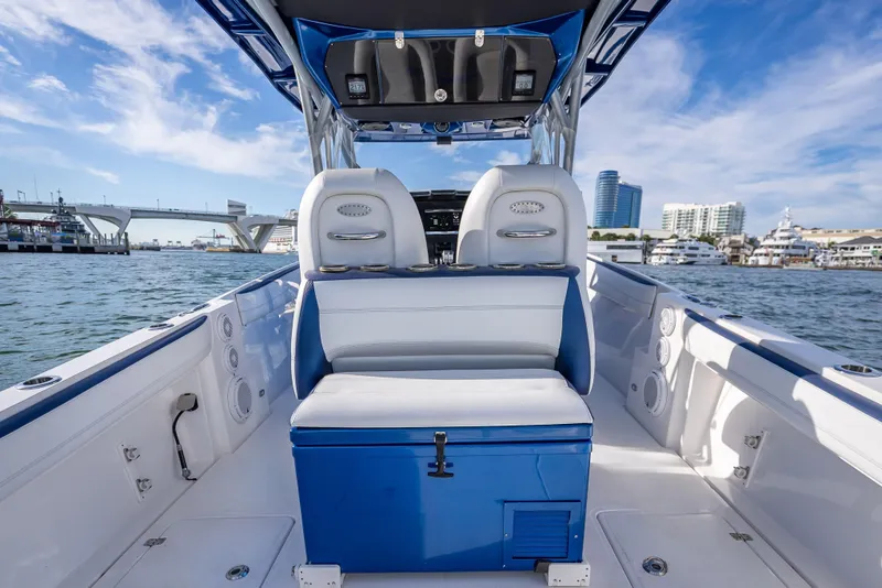 Slide: The Image of 2015 Nor-Tech 340 Sport Center Console boat interior with blue and white seating, dockside view. - 20