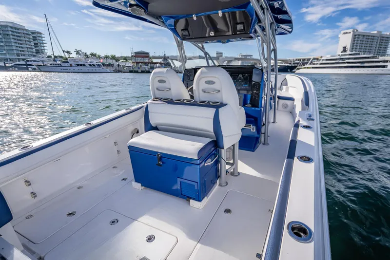 Slide: The Image of 2015 Nor-Tech 340 Sport Center Console boat interior with seating and console, docked in marina. - 21