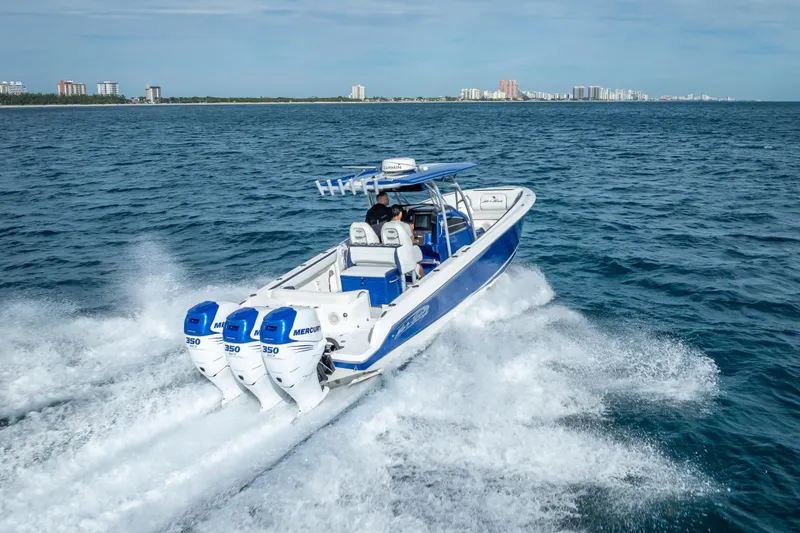Slide: The Image of 2015 Nor-Tech 340 Sport Center Console cruising on open water with triple Mercury engines. - 23