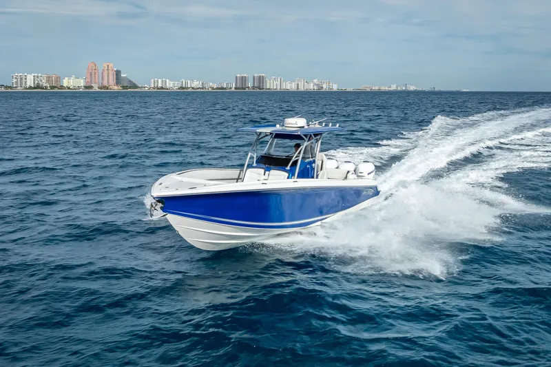 Slide: The Image of 2015 Nor-Tech 340 Sport Center Console cruising on open water near city skyline. - 26