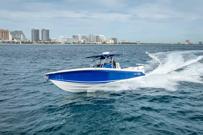 Slide: The Image of 2015 Nor-Tech 340 Sport Center Console cruising on open water near city skyline. - 28