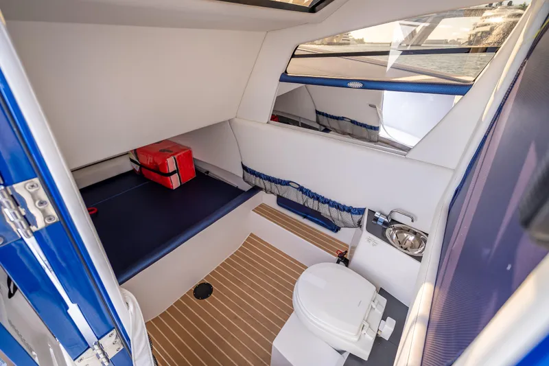 Slide: The Image of 2015 Nor-Tech 340 Sport Center Console cabin interior with seating and marine toilet. - 30