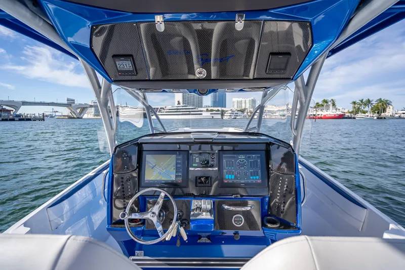 Slide: The Image of 2015 Nor-Tech 340 Sport Center Console boat dashboard with navigation screens on open water. - 38