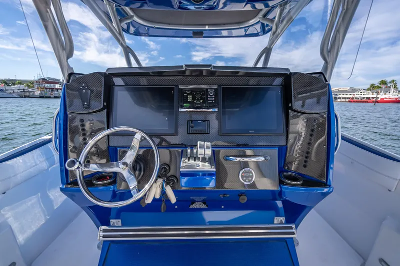 Slide: The Image of 2015 Nor-Tech 340 Sport Center Console dashboard with dual screens and steering wheel. - 40