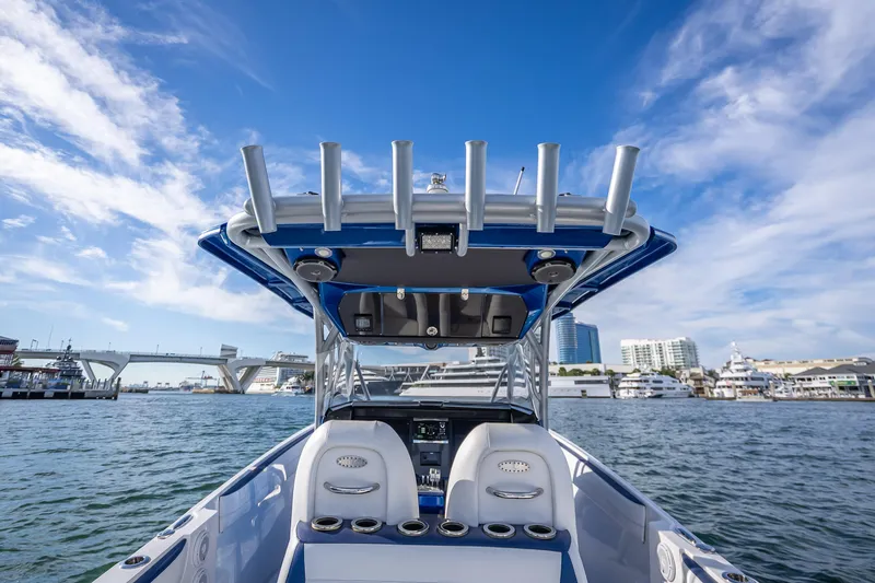 Slide: The Image of 2015 Nor-Tech 340 Sport Center Console boat on water, clear sky, urban backdrop. - 43