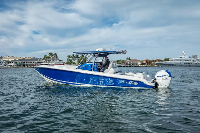 Slide: The Image of 2015 Nor-Tech 340 Sport Center Console boat on water, featuring blue hull and Mercury engines. - 5