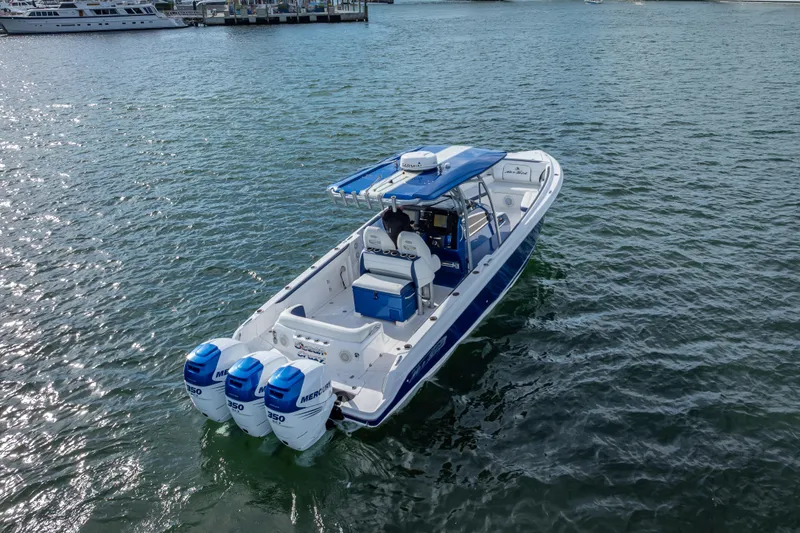 Slide: The Image of 2015 Nor-Tech 340 Sport Center Console boat on water, featuring triple Mercury engines. - 7