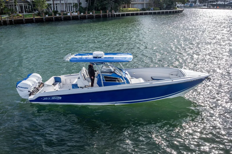 Slide: The Image of 2015 Nor-Tech 340 Sport Center Console boat on water, featuring blue hull and Mercury engines. - 9