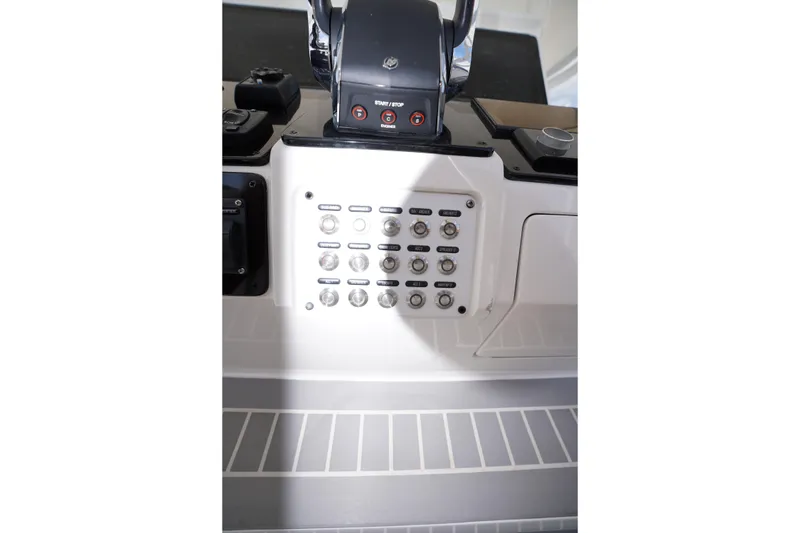 Slide: The Image of Control panel of a 2015 Intrepid 400 Cuddy boat, featuring various switches and buttons. - 111
