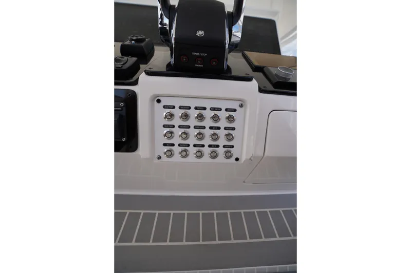 Slide: The Image of Control panel of a 2015 Intrepid 400 Cuddy boat with switches and controls. - 112
