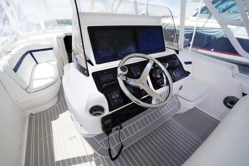 Slide: The Image of Helm of 2015 Intrepid 400 Cuddy boat with modern controls and steering wheel. - 119