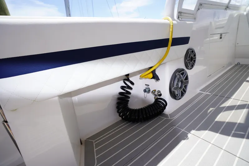 Slide: The Image of Intrepid 400 Cuddy 2015 boat interior with speakers and coiled hose on deck. - 125