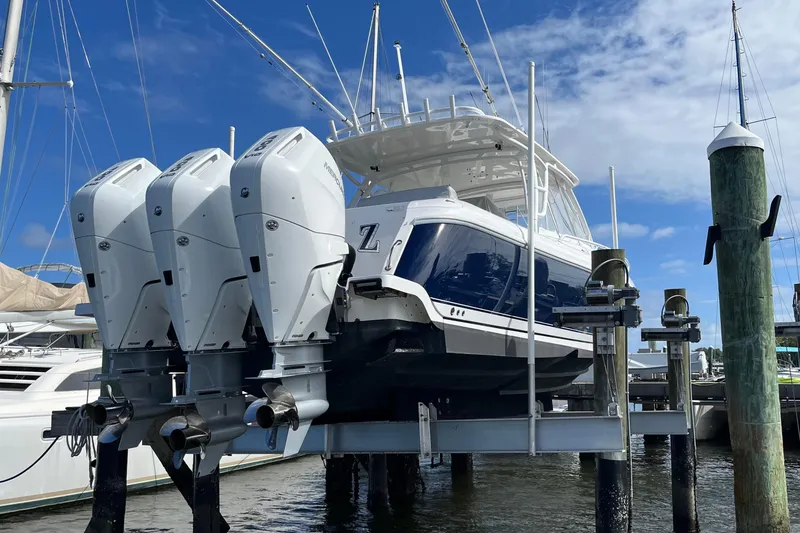 Slide: The Image of 2015 Intrepid 400 Cuddy boat with triple outboard engines on a lift. - 128