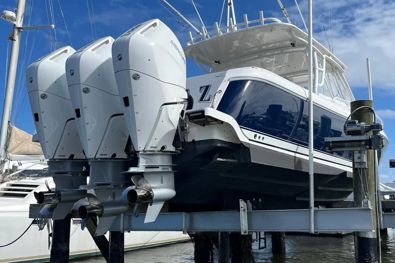 Slide: The Image of 2015 Intrepid 400 Cuddy boat with triple Mercury outboard engines on a lift. - 129