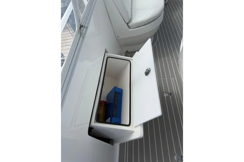 Slide: The Image of Storage compartment on 2015 Intrepid 400 Cuddy boat with open door and visible contents. - 17