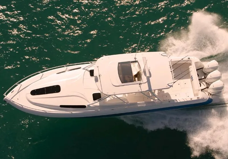 Slide: The Image of 2015 Intrepid 400 Cuddy boat docked at marina under clear blue sky. - 2