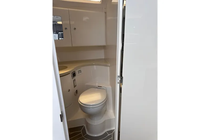 Slide: The Image of 2015 Intrepid 400 Cuddy boat bathroom interior with toilet and storage cabinets. - 30
