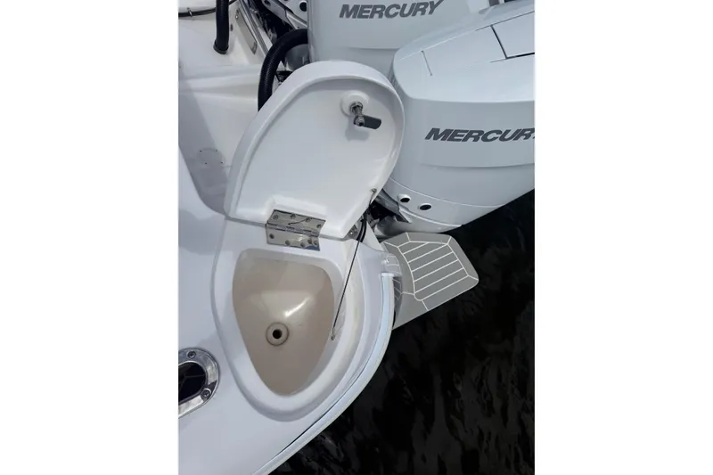 Slide: The Image of Open hatch on 2015 Intrepid 400 Cuddy boat, revealing a sink near Mercury engines. - 33