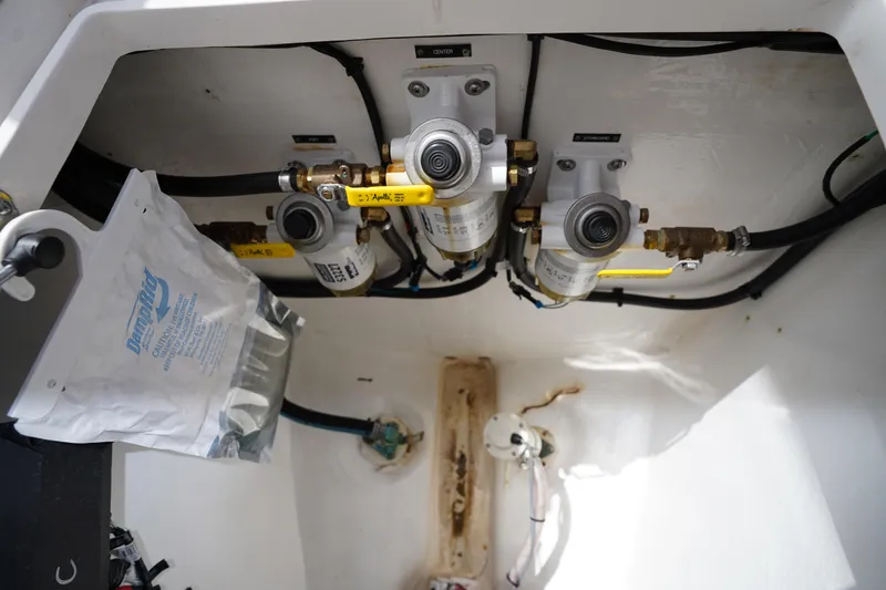 Slide: The Image of Engine compartment of a 2015 Intrepid 400 Cuddy boat, showcasing fuel filters and hoses. - 60