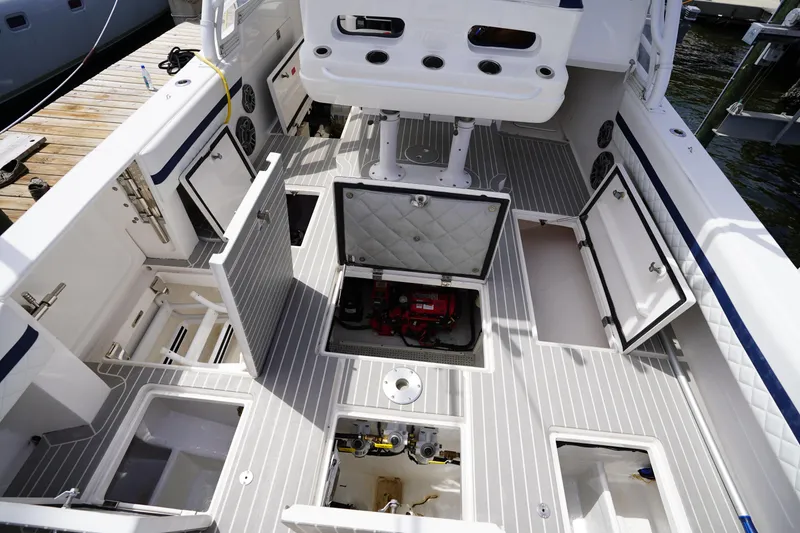 Slide: The Image of 2015 Intrepid 400 Cuddy boat interior with open storage compartments and visible engine. - 61