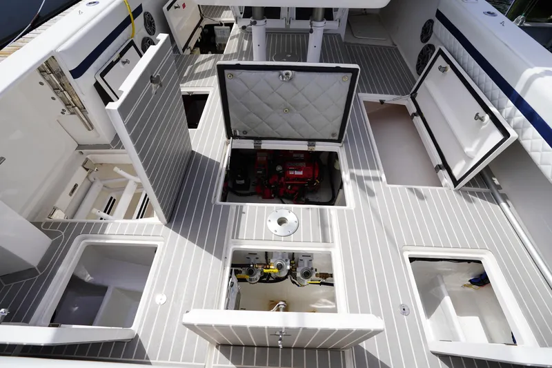 Slide: The Image of Open storage compartments on a 2015 Intrepid 400 Cuddy boat deck. - 62