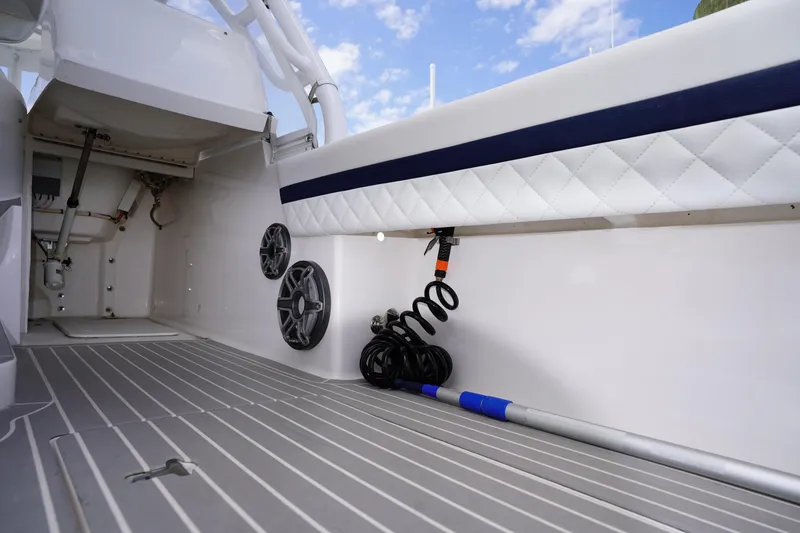 Slide: The Image of 2015 Intrepid 400 Cuddy boat interior with speakers and coiled hose on deck. - 79