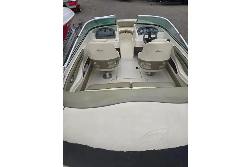 Slide: The Image of 2005 Sea Ray 200 Bow Rider interior with beige seating and steering wheel. - 3