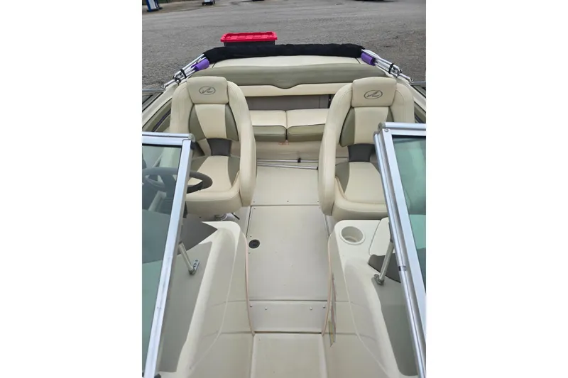 Slide: The Image of 2005 Sea Ray 200 Bow Rider interior with beige seating and windshield. - 5