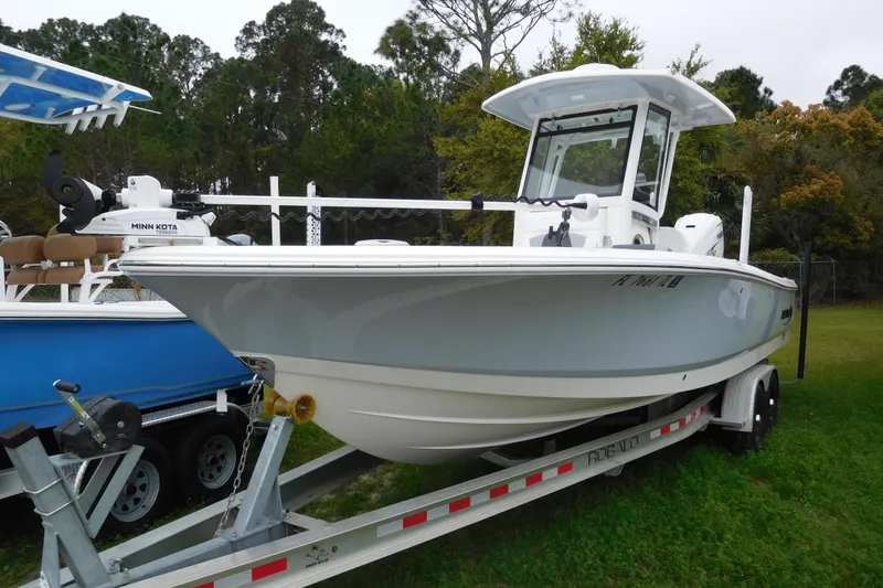 Slide: The Image of 2023 Robalo 266 Cayman boat on trailer, surrounded by greenery. - 5