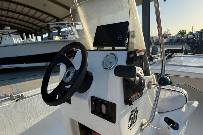 Slide: The Image of 2017 Mako Pro Skiff 17 CC boat console with steering wheel and controls. - 13