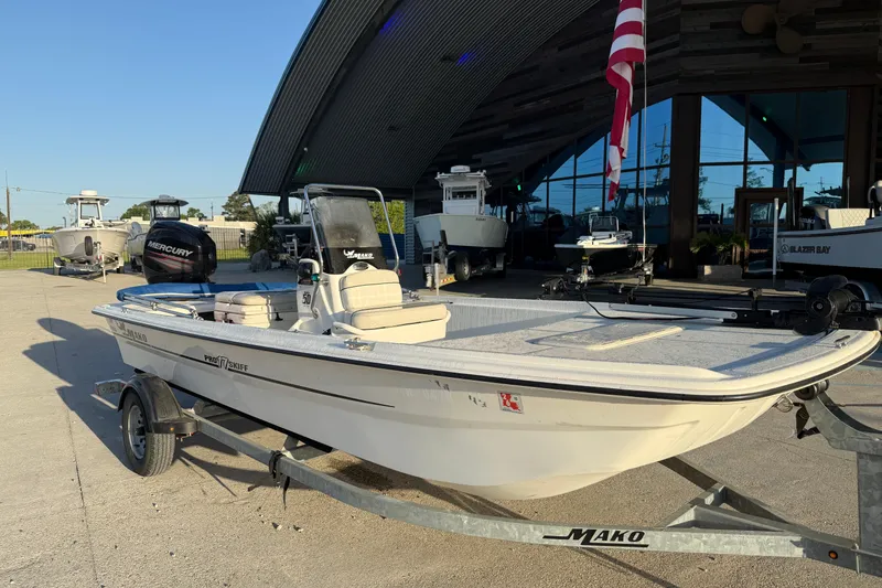 Slide: The Image of 2017 Mako Pro Skiff 17 CC boat on trailer, parked outside a showroom. - 4