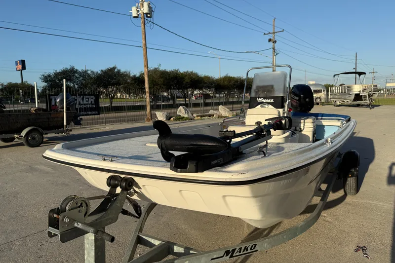 Slide: The Image of 2017 Mako Pro Skiff 17 CC boat on trailer, parked outdoors under clear sky. - 6