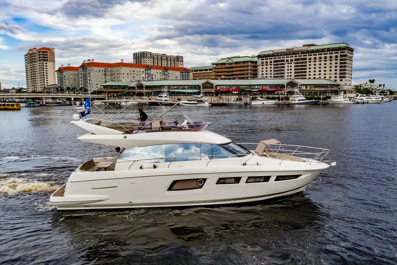 Slide: The Image of 2013 Prestige 500 Fly yacht cruising near urban waterfront buildings under cloudy sky. - 2