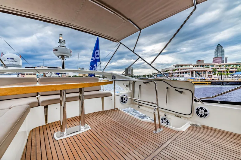 Slide: The Image of Luxurious 2013 Prestige 500 Fly yacht deck with cityscape view, featuring elegant seating and wooden flooring. - 35