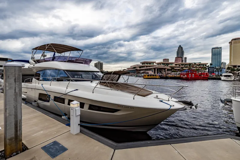Slide: The Image of Prestige 500 Fly 2013 yacht docked at marina with city skyline backdrop. - 4