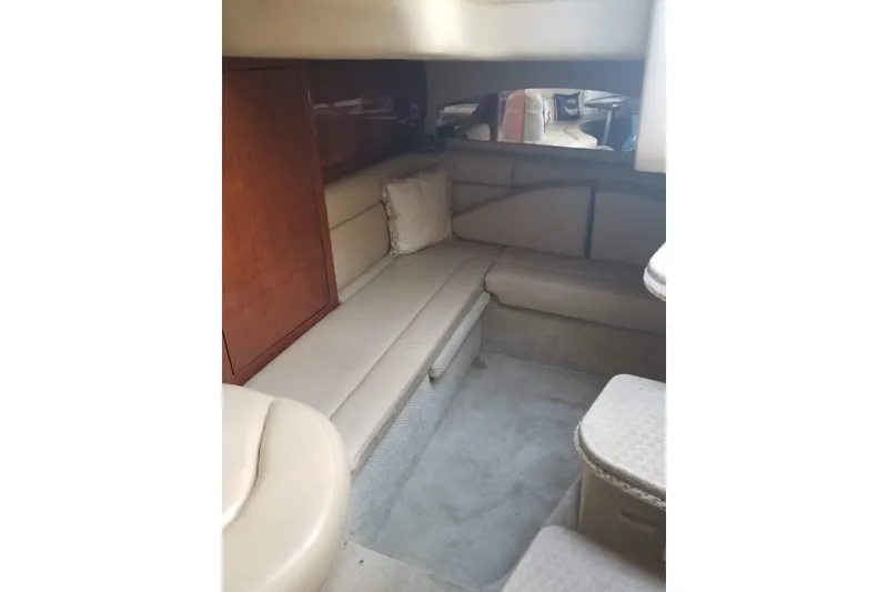 Slide: The Image of Interior of 2004 Sea Ray 360 Sundancer yacht with beige seating and wooden cabinetry. - 12