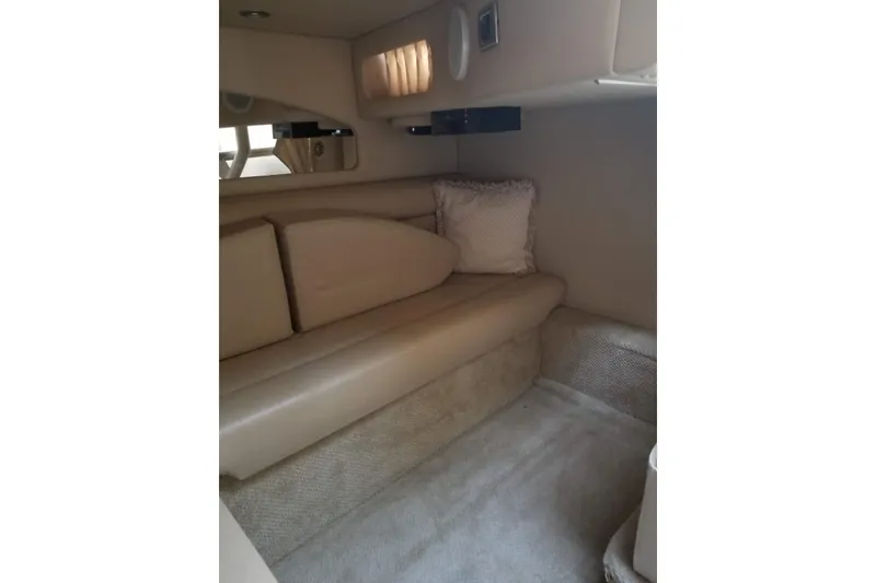 Slide: The Image of Interior cabin of 2004 Sea Ray 360 Sundancer with beige seating and soft lighting. - 13